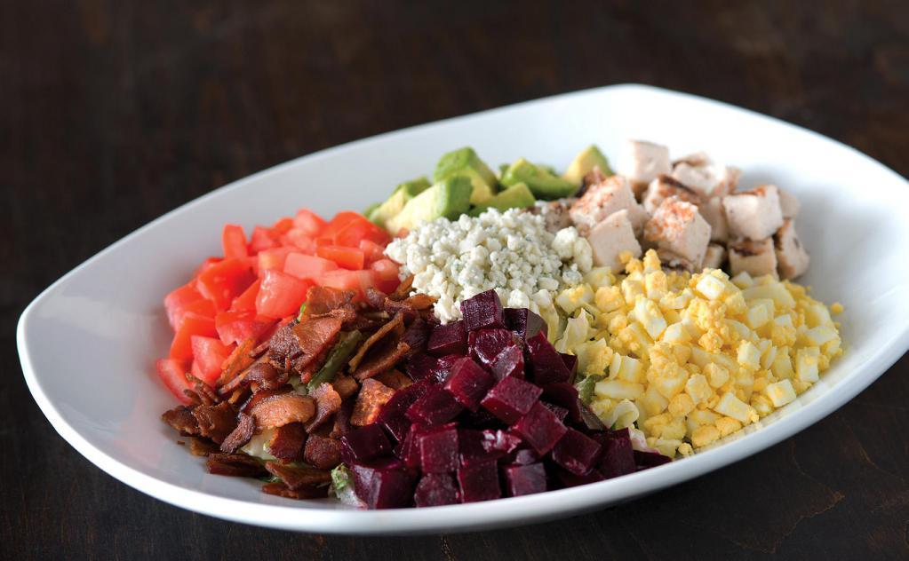 California Cobb Salad · Nueske's applewood smoked bacon, avocado, chicken, tomatoes, chopped egg, fresh basil, and Gorgonzola with housemade herb ranch or bleu cheese dressing. Gluten-free ingredients.