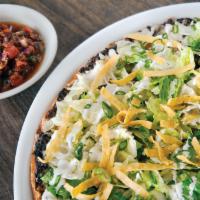 Tostada Pizza  · Crisp lettuce, tortilla strips and house made herb ranch top this hearth-baked crust with la...