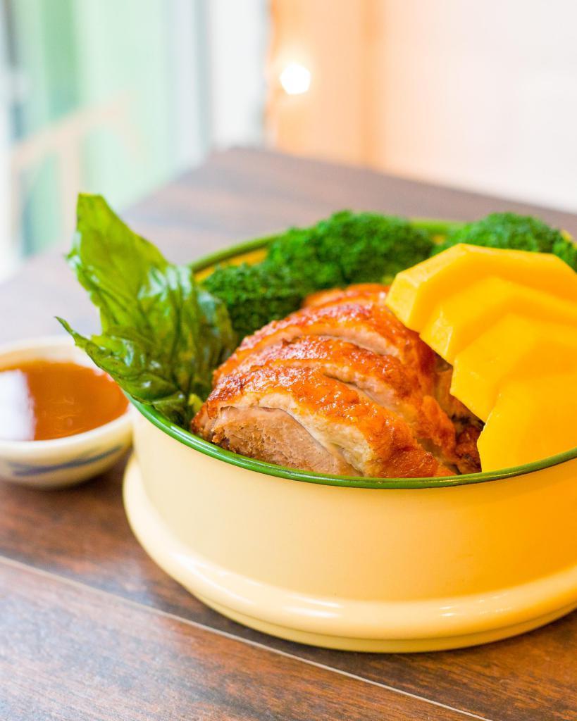 Superior Duck · A crispy half boneless roasted duck with delicious brown mango sauce, served on a bed of boiled broccoli and ripe mango and topped with crispy basil. Without rice.