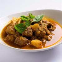 Burmese Pork Curry · Pork simmered in curry served with potatoes and pickled mangoes. Spicy.