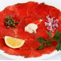 Carpaccio · Thin slices of raw steak, red onion, surfine capers, spicy mustard, Italian parsley and lemon.