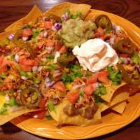Agave Nachos · Crispy corn chips and cheese baked to perfection then topped with beans, sour cream, guacamo...