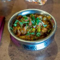 Baigan Bhartha · Eggplant roasted in the tandoor and cooked with green peas, fresh tomatoes, onion, ginger an...