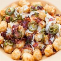 Loaded Tots · Tots smothered in cheese, bacon, onions, and jalapenos, served with a side of zesty red sauc...