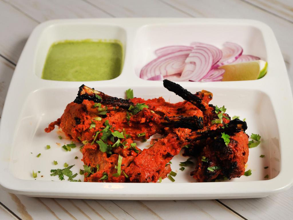 Lamb Chops · Tender lamb chops marinated in Indian spices and char-grilled on skewers tandoori style in a clay oven.