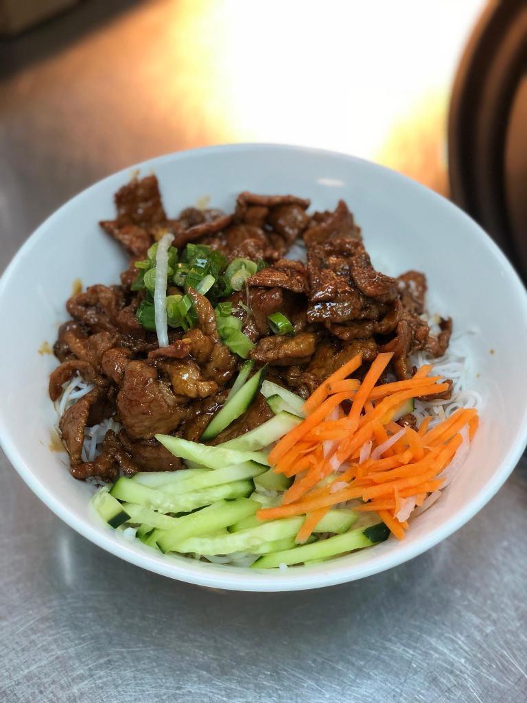 Vermicelli with Pork · A bowl served with carrot strips, cucumbers, chopped peanuts, onions over shredded lettuce and bean sprouts with a side of fish sauce.