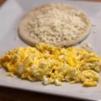 Huevos Pericos · Scrambled eggs, chopped onions, and tomatoes. Served with arepa paisa topped with white chee...