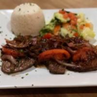 Higado Encebollado · Perfectly cooked liver steak topped with grilled onions. Served with white rice, red beans a...
