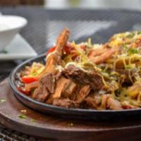 Fajitas Los Tres Amigos · Grilled steak, chicken, and shrimp topped with onions, peppers, and cheese. Served with flou...