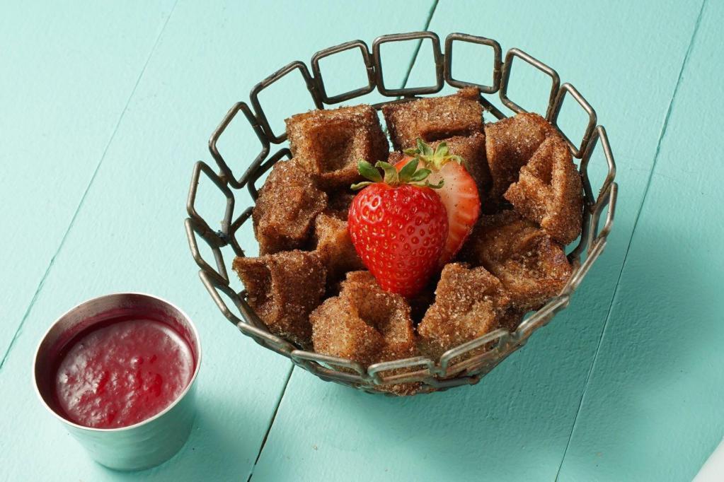 Churro Waffle Bites · Waffle-pressed churro with a choice of vegan Callebaut chocolate or strawberry dipping sauce. Vegan.