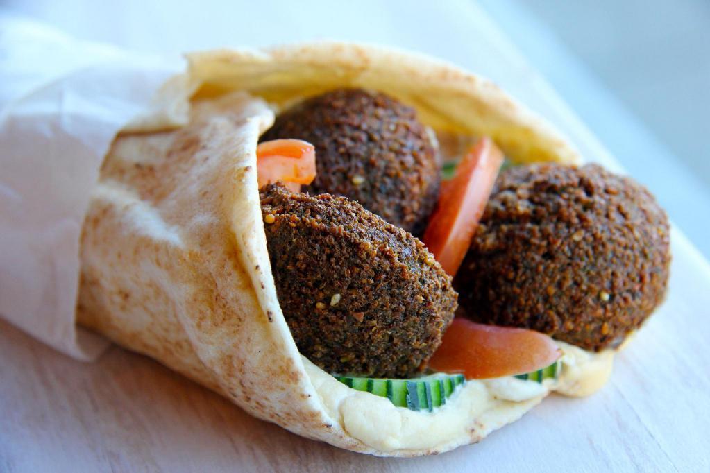 Falafel · Fried ground chickpeas with spread of hummus, parsley, onion and herbs with lettuce, tomato, onion and tzatziki sauce.