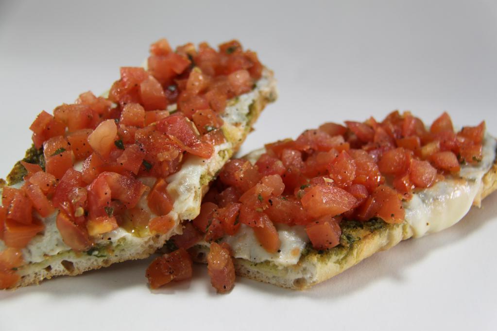 Bruschetta · Fresh Italian bread, basil pesto and sliced mozzarella cheese baked in the oven and topped with our homemade marinated tomato relish