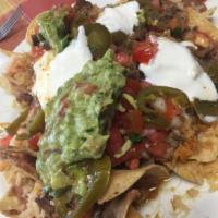 Volcano Nachos · Tortilla chips with melted cheese, refried beans, pico de gallo, sour cream, guacamole, and ...