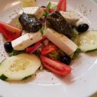 Mama Lambrou's Greek Salad · Romaine, tomatoes, cucumbers, onions, peppers, olives, stuffed grape leaves and feta cheese.