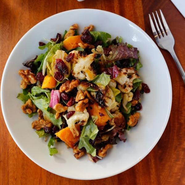 Roasted Vegetable Salad · Organic spring mix, dried cranberries, cauliflower,  butternut squash, Brussels sprouts, candied walnuts and champagne vinaigrette. Gluten-free.