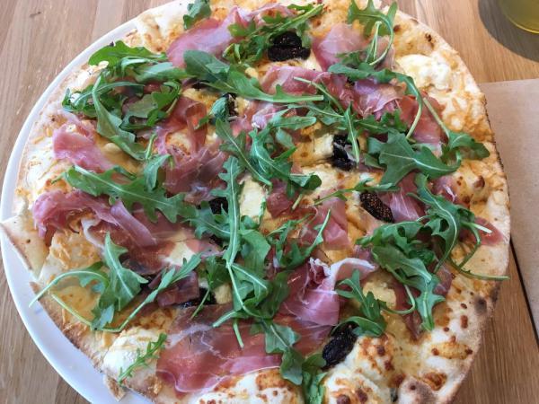 Prosciutto and Fig Pizza · White pizza with black mission figs, goat cheese and arugula.