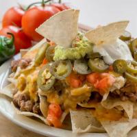 Nacho Supreme · Tostada chips, slow cooked beans, queso sauce, jalapenos, guacamole, sour cream and tomato. ...