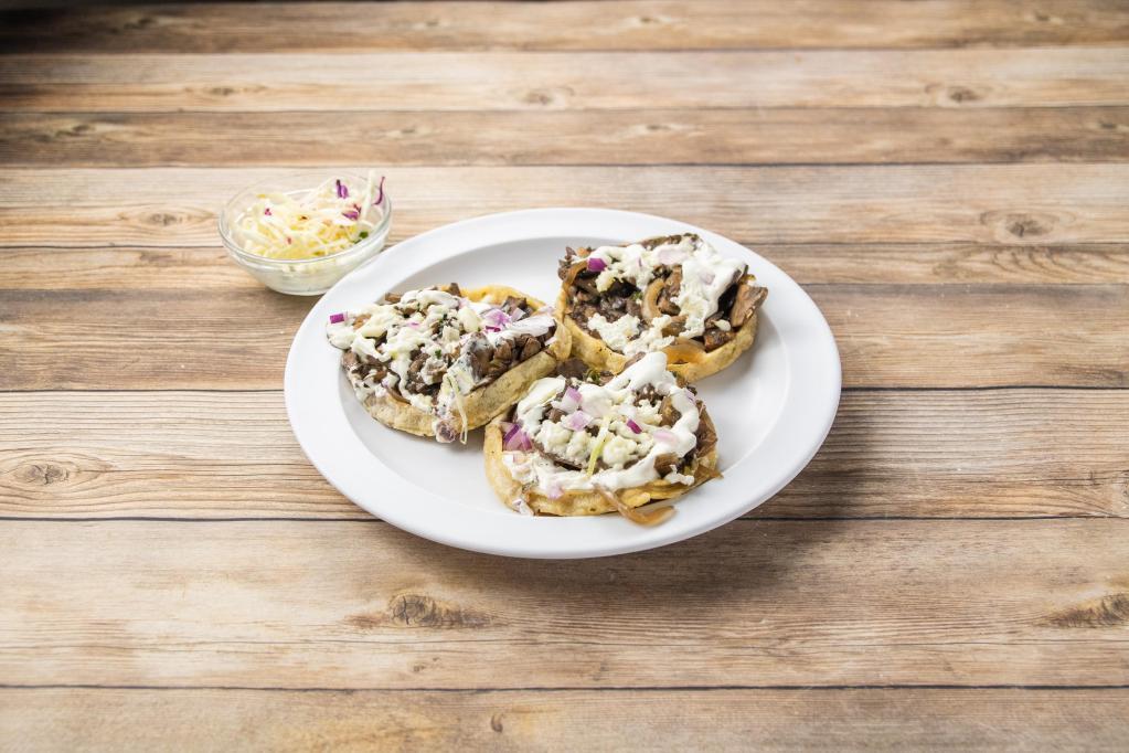 Sopes de Hongos · 3 homemade thick tortillas topped with mushrooms, epazote, queso, sour cream, and onions Vegetarian.