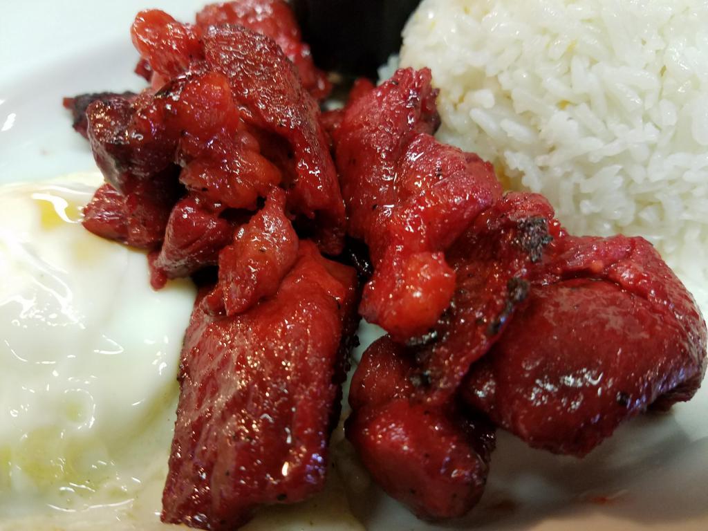 Tosilog · Pan fried Sliced pork in house sweet marinade served with 2 eggs and scoop of garlic rice.