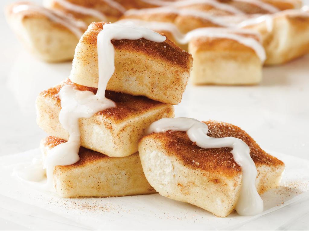 Cinnasquares · Fresh-baked, buttery pastry topped with cinnamon and sugar, served with a side of vanilla icing.
