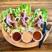 Cajun Whitefish Lettuce Wraps · 3 tender lettuce leaves topped with Cajun Whitefish, grilled onions, and coleslaw. Served wi...