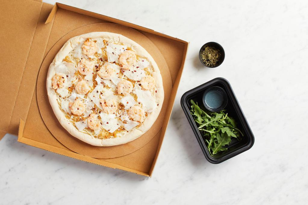 Take and Bake Shrimp Scampi Pizza  · READY TO BAKE - Housemade lemon-garlic shrimp with caramelized onions, mozzarella, Parmesan, and red chili, topped with fresh arugula and wild Greek oregano.