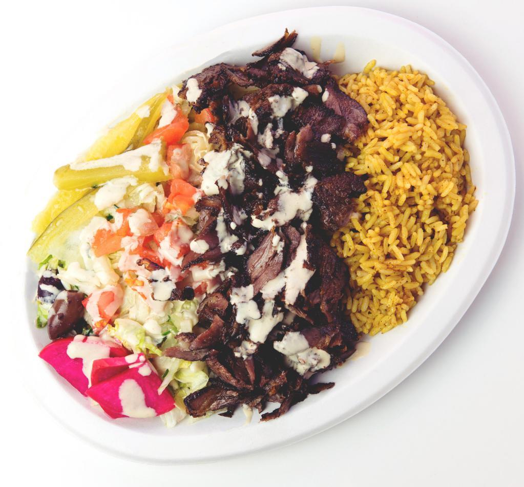 Shawarma Plate · 100% lamb made with our signature spices, cooked slowly on a stand up rotisserie and thinly sliced. Served over choice of salad or seasoned rice (or both for addt'l charge) with a pita bread.