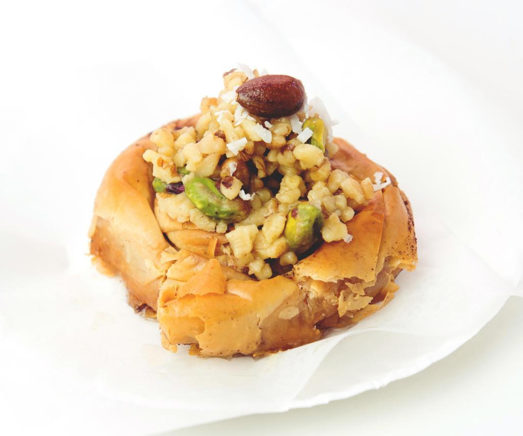 Mabrumeh · Twisted fillo dough topped with mixed nuts (walnuts, almonds and pistachios) and coconut flakes.