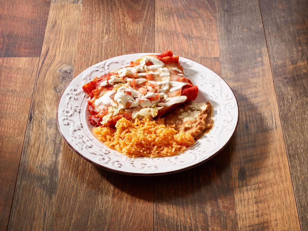 Enchiladas Tapatias · 3 soft corn tortillas filled with chicken and covered with guajillo sauce, goat cheese and sour cream. Served with rice, beans and corn tortillas.