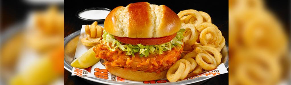 Hooters Original Buffalo Chicken Sandwich · Everything you love about our wings, but in a sandwich. Hand-breaded chicken breast tossed in your favorite wing sauce, topped with lettuce and tomato and served on a toasted brioche bun.