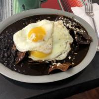 Mole Sauce Chilaquiles · homemade chips tossed with homemade mole ,2 scrambled or fried eggs on top,finished with mex...