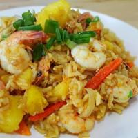 Pineapple Fried Rice · Thai jasmine rice stir fried with pineapples, raisins, onions, tomatoes, egg and choice of p...