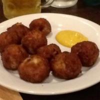 Sauerkraut Balls · Hand rolled with our homemade corned beef and served with tangy horseradish mustard.