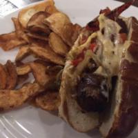 Stout Bratwurst · Topped with peppers, onions, house mustard and sauerkraut on a warm pretzel bun.