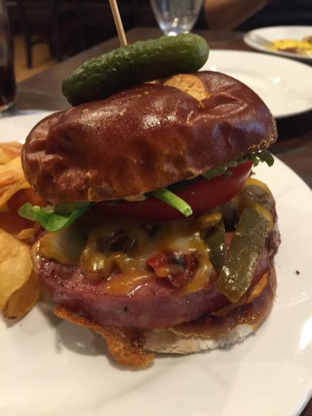 German Bologna · Served on a warm pretzel bun with lettuce, tomato, cheddar cheese, onions, house mustard and peppers.