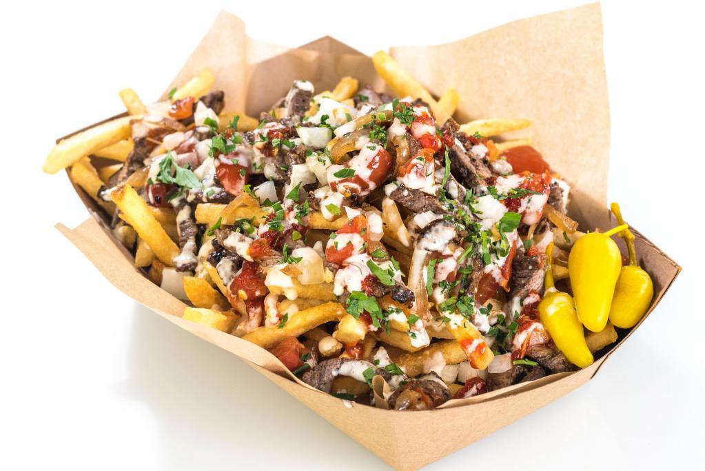 Beef Shawarma Fries · Crispy fries topped with shawarma, grilled tomatoes and onions, tahini sauce and hot sauce.