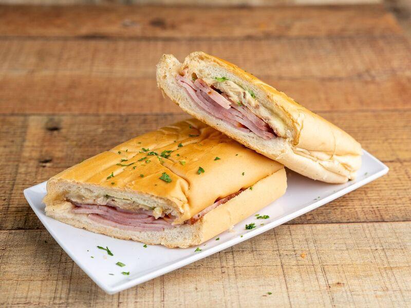 Cubano Regular Sandwich · All-time favorite sandwich. Right down hearty and mmm, so good! Ham, cheese, pork, a touch of pickles on Cuban bread.