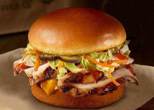 Kickin' Buffalo Chicken Sandwich · Tender smoked marinated chicken with spicy buffalo sauce, crisp and creamy cabbage slaw, cheddar cheese, and jalapeño peppers stacked on a toasted bun.