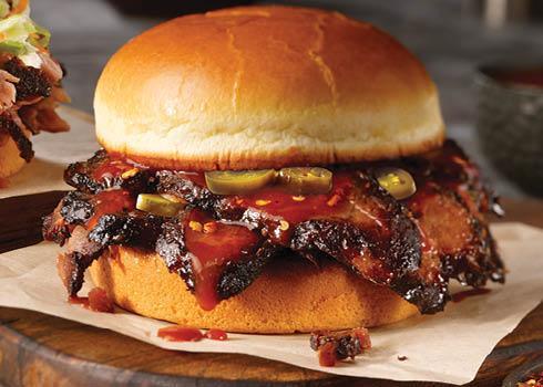 Texas Hot Brisket Sandwich · Chopped or sliced smoked brisket topped with our Texas Hot Sauce and jalapeños, stacked on a toasted bun.