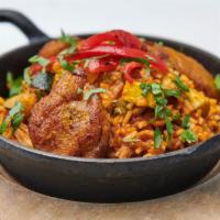 Arroz con Pollo · Chicken and rice blended with peppers and maduros.