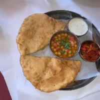 Cholle Bhature (2 pcs) · Two pieces of puffed bread made with refind flour and served with curried chickpeas, raita a...
