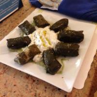 Dolmadakia · Stuffed grape leaves filled with rice and herbs. Served with 2 sides of pita bread.
