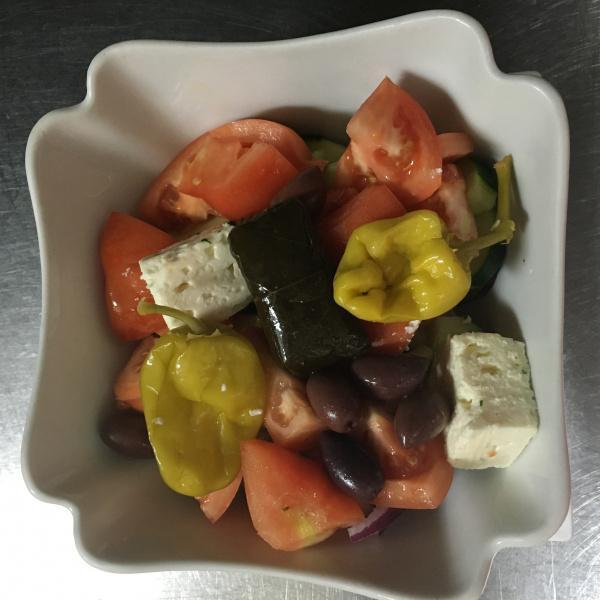 Horiatiki Salad · Classic village Greek salad with tomato, onion, cucumbers, Kalamata olives, feta, extra virgin olive oil and red onions.