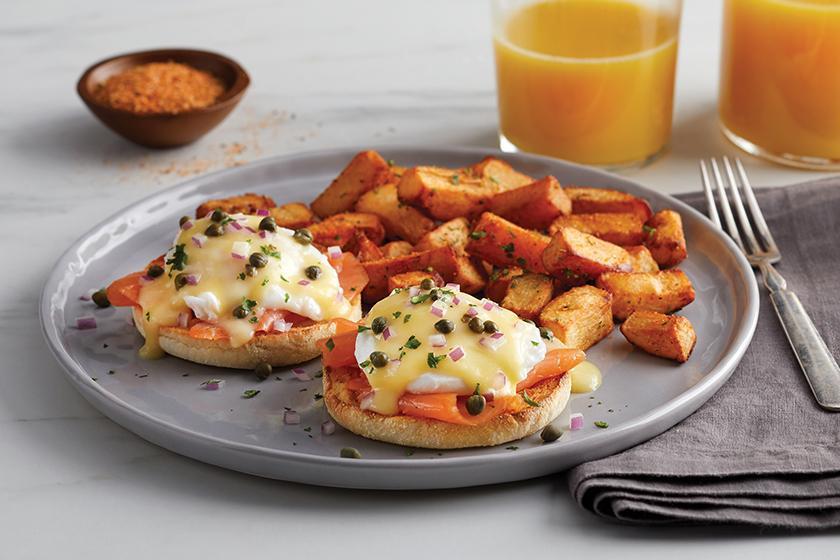 Smoked Salmon Benedict · Cold-smoked Atlantic salmon and poached eggs, topped with hollandaise sauce, diced red onions and capers on a grilled English muffin.