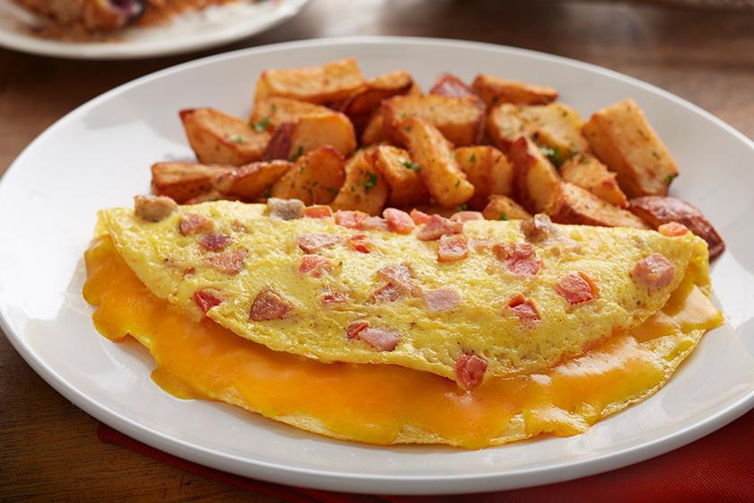 Bacon, Ham & Sausage Omelet · Three eggs, hickory-smoked bacon, ham, pork sausage, andouille sausage, tomato and melted cheddar cheese. Served with roasted potatoes.