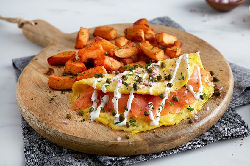 Smoked Salmon Omelet · Three eggs, cold-smoked Atlantic salmon, diced red onions, capers and sour cream sauce. Served with roasted potatoes.