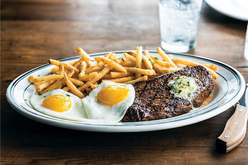 Steak & Eggs · 28-day aged 10 oz. USDA Choice New York Strip. House-made herb butter available upon request. Served with roasted potatoes and two eggs.