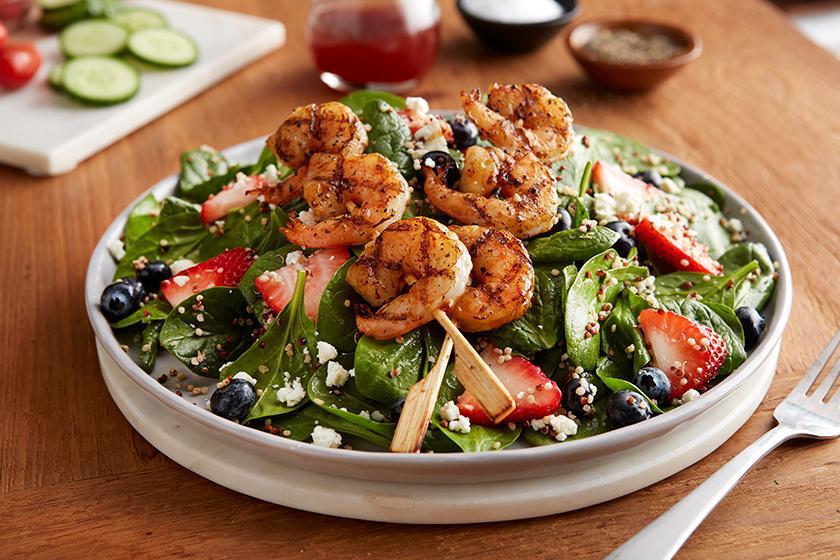 Berry Spinach & Shrimp Quinoa Salad · Two skewers of grilled shrimp, fresh strawberries, blueberries, feta and quinoa on baby spinach tossed in fat-free raspberry vinaigrette.