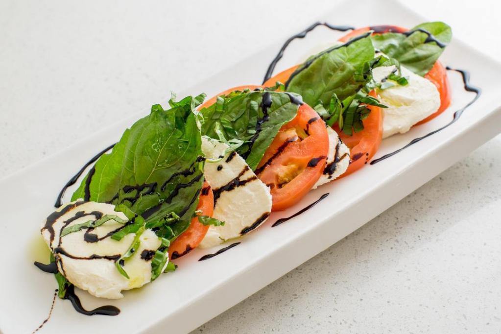 Caprese Salad · Sliced mozzarella and plum tomatoes with fresh basil in a balsamic reduction.