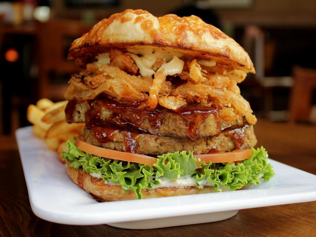 Mama's Meatloaf Burger · Old-fashioned, scratch-made meatloaf with tangy red glaze, crispy onion straws, lettuce, tomato, and garlic mayo on an onion-cheese kaiser. Served with choice of side.